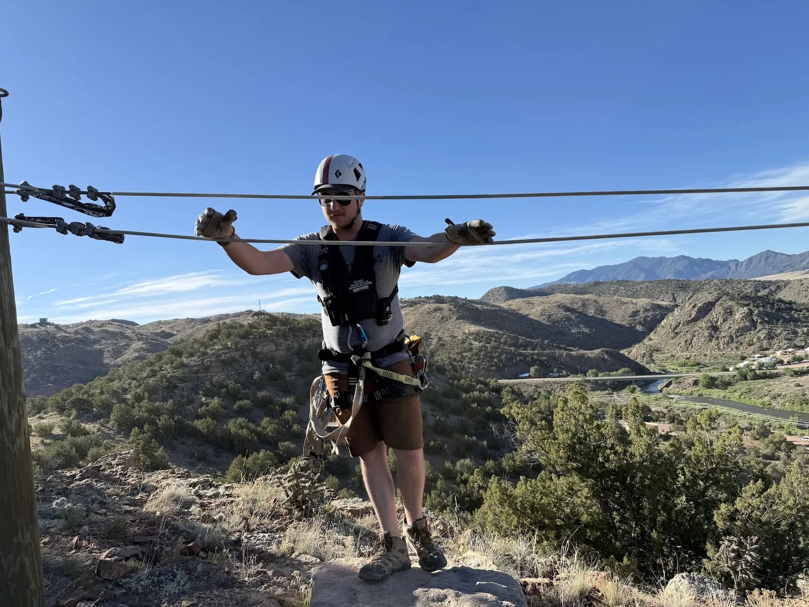 Guest photo by Walt on Google: a guest in helmet and harness, arms out between the cables above the Arkansas River valley
